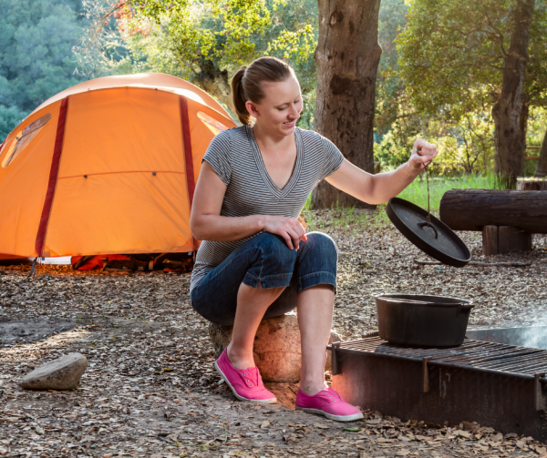 woman cooking whilst camping